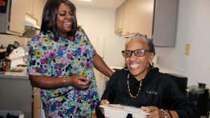 Dierdre Mayes (seated) shares a laugh with her caregiver, Jeanne Cooper. Photo by Alyssa Branum